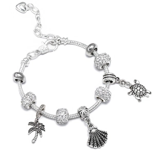 Detail of silver-plated bracelet featuring turtle, shell, and palm tree charms