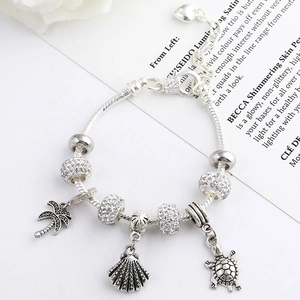 Macro detail of silver heart extender chain with ocean themed shell and turtle charms