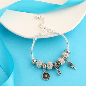 Detail of silver snake chain bracelet with heart extender and summer theme charms