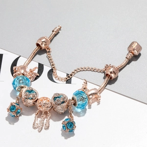 Λεπτομέρεια βραχιολιού rose gold με μπλε κρυστάλλινες χάντρες και κρεμαστό ονειροπαγίδα