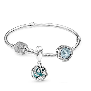 Detail of silver snake chain bracelet with crescent moon star and stork enamel charms