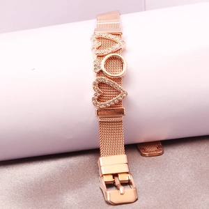 Detail of rose gold mesh bracelet featuring heart charms and crystal ring slider
