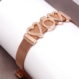 Detail of rose gold mesh bracelet featuring zircon hearts and metallic circular charms