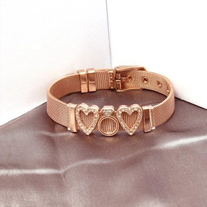Detailed macro view of rose gold mesh bracelet featuring zircon heart and ring charms