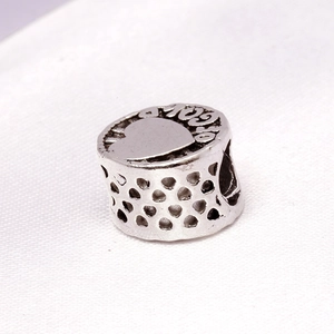 Makro-Detail des antiken Silber-Anhängers mit Herzdesign und Gold-Gravur auf Schmuck