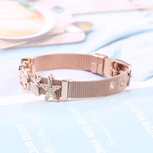 Detail of rose gold mesh bracelet with starfish, shell, and tree of life charms