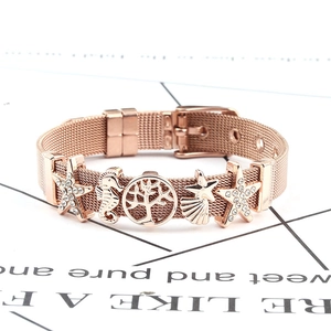 Detail of rose gold mesh bracelet featuring starfish, seahorse and tree of life charms