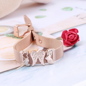 Detailed view of rose gold mesh bracelet featuring angel wing and heart metal sliders