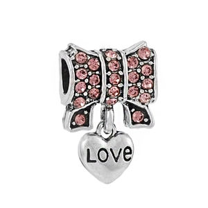 Detalle de dije de lazo plateado con circonitas rosas y colgante de corazón grabado Love
