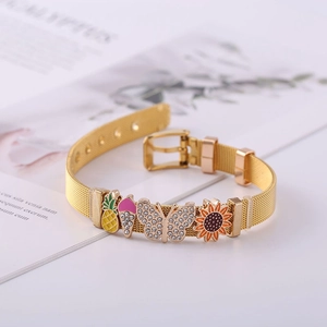 Close-up of a gold mesh bracelet with charms including a pineapple and sunflower