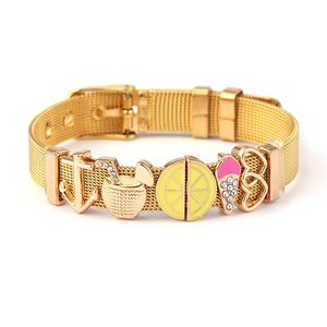 Detail of gold mesh watch-band bracelet featuring summer charms like anchor and lemon