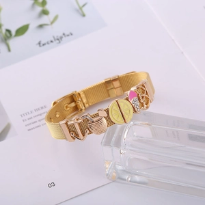 Detail of gold mesh watchband bracelet with enamel anchor, lemon, and ice cream charms