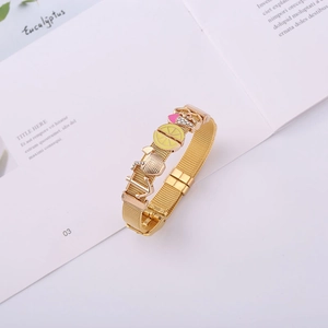 Detail of gold mesh keeper bracelet featuring nautical charms and colorful fruit pendants