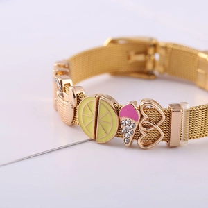 Detail of gold mesh bracelet featuring lemon, ice cream, and heart charms with buckle