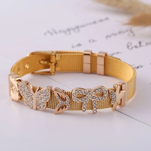 Golden mesh strap bracelet with crystal butterfly charms and buckle clasp on white decor