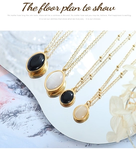 Detail of oval cat eye stone pendants on gold necklaces displayed on a mirror surface
