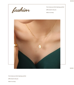 Close-up of vintage gold titanium necklace with oval opal pendant on model