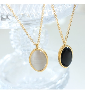 Detail of oval cat eye stone pendants in gold finish on slender link chains