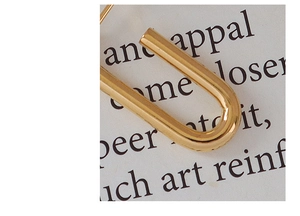 Makroaufnahme von U-förmigen 18k vergoldeten Edelstahl-Ohrringen mit poliertem Finish