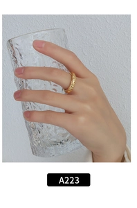 Detail of a 18K gold-plated twisted ring featuring a hammered texture on a model hand