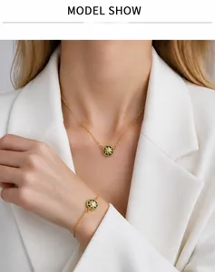 Detail of model wearing green enamel star compass necklace and bracelet set in gold