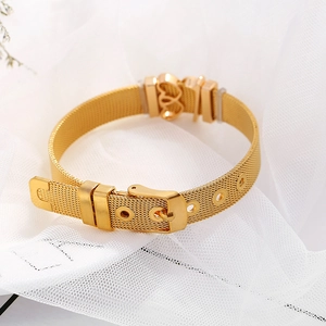 Goldenes Mesh-Armband mit Gürtelschnalle und Herzanhänger auf weißem Hintergrund