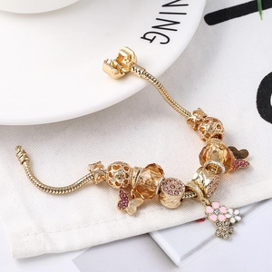 Goldenes Charm-Armband mit Schmetterlingsanhängern und rosa Blumen an Schlangenkette