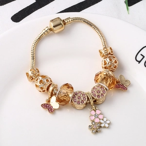 Goldenes Schlangenarmband mit bernsteinfarbenen Glasperlen und rosa Schmetterlingsanhänger
