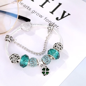 Silver beaded bracelet with sea blue glass beads and green clover charm on heart clasp