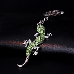 Sparkling green crystal lizard keychain with silver alloy finish on a black background