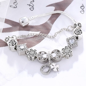 Silver charm bracelet with four-leaf clover and horseshoe pendants on snake chain