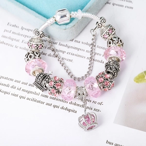 Close-up of pink faceted crystal beads and silver crown charm on a charm bracelet