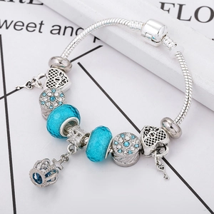 Versilbertes Schlangenarmband mit blauen Glasperlen und Kronen-Schlüssel-Anhänger