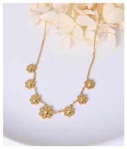 Nahaufnahme des eleganten 18k vergoldeten Gänseblümchen-Fußkettchens mit Blumen-Anhängern