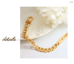 Detailansicht eines klobigen goldenen Panzerarmbandes mit U-Verschluss und Metallelement