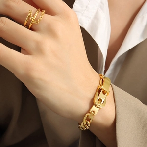 Goldenes Gliederkettenarmband mit U-Verschluss und passenden mehrlagigen Ringen