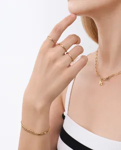 Set di gioielli dorati con anelli minimalisti, collana con stella e bracciale su modella