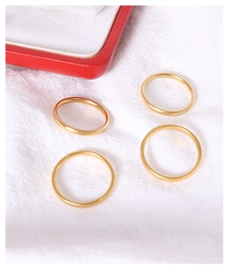 Set di quattro anelli minimalisti in titanio dorato su tessuto bianco strutturato