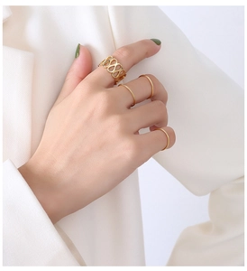 Dettaglio dell'anello con simbolo dell'infinito e fedi dorate su mano di modella