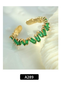 Macro di anello regolabile in oro con pietre verdi taglio baguette su sfondo bianco