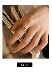 Detailed view of triple-layered irregular gold ring on hand with elegant book background