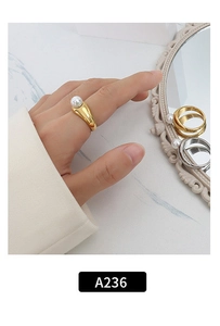 Close-up of elegant gold ring with white pearl on marble surface for women