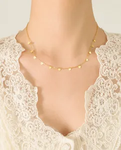 Close-up of elegant gold choker necklace with multiple heart charms on a model