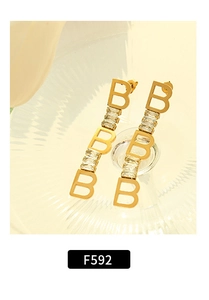 Detail shot of vintage 18k gold plated long earrings with B letters and zircon crystals