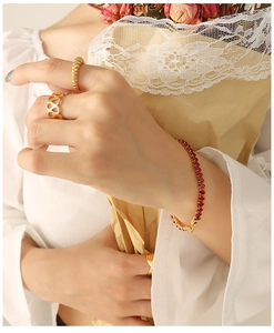 Close-up of vintage 18k gold-plated bracelet with red gemstones and gold rings