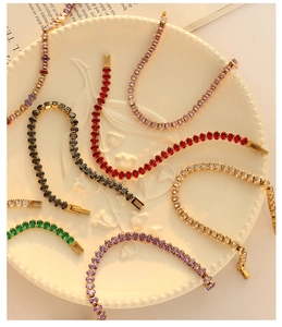 Detail of colorful oval-cut zircon tennis bracelets on a vintage embossed white ceramic plate