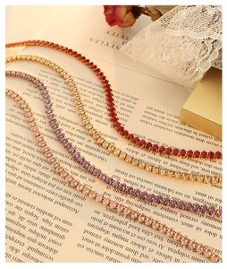 Close-up of titanium steel tennis necklaces with colorful oval-cut gemstones