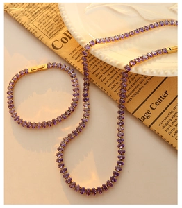 Detail of 18k gold tennis necklace and bracelet set with oval purple zircon stones