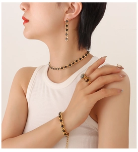 Dettaglio del set di gioielli vintage placcati oro con zirconi neri indossati da modella
