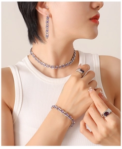 Dettaglio del set catena cubana argento con zirconi viola indossato da una modella